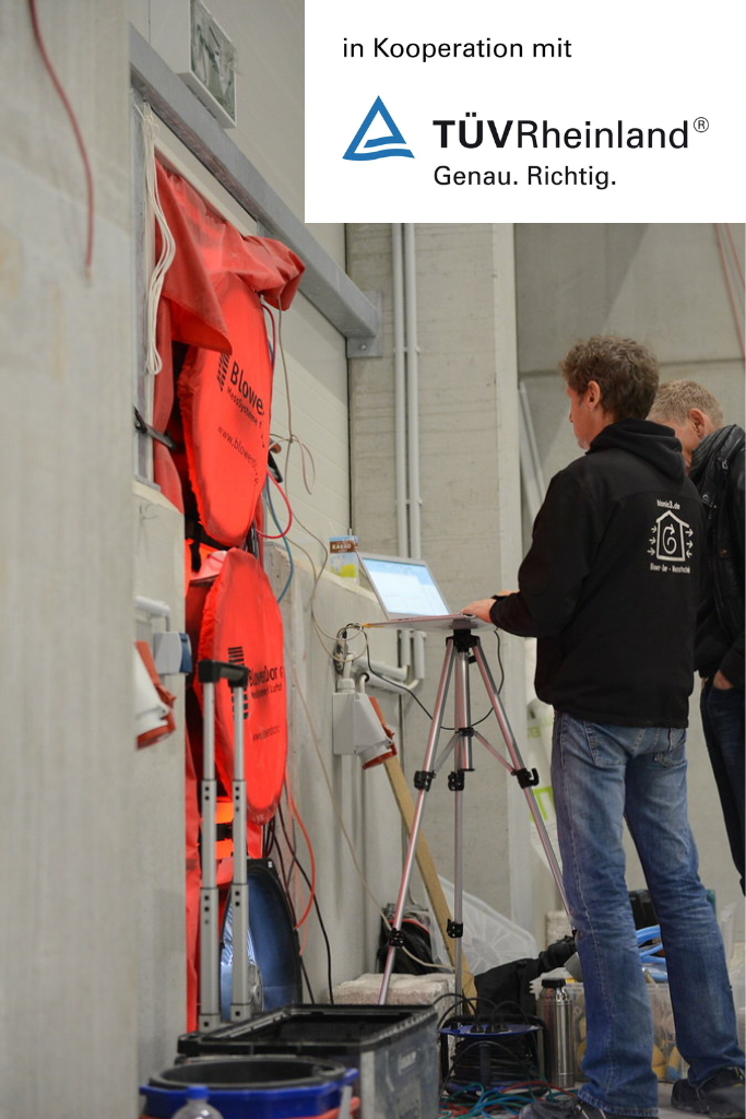 Zwei Messtechniker bei Blower-Door-Test in großer Halle – verschiedene Blower-Door-Geräte im Einsatz, Rückansicht